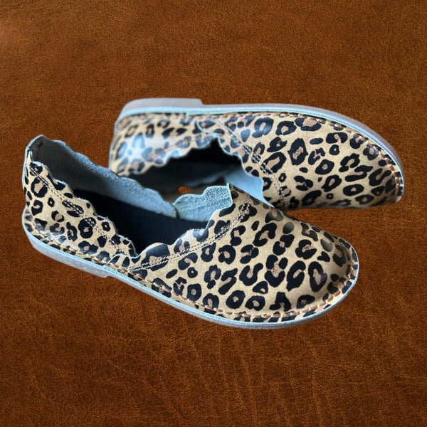Pair of leopard print shoes on a brown background